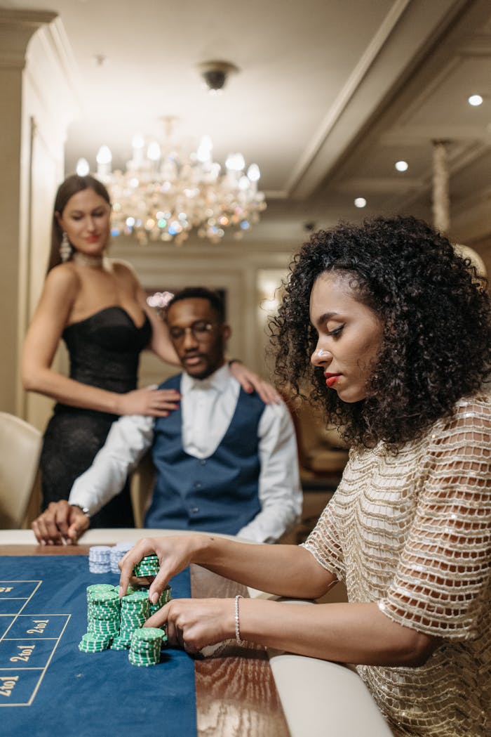 Women and man enjoying a night of gambling at a casino table with poker chips.